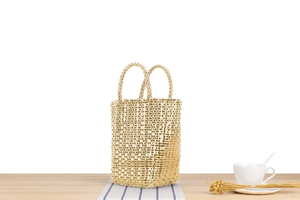Détails de la texture d'un sac à main tissé doré sur une table pour un style de vacances