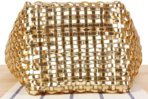 Gros plan détaillé d'un sac tissé métallique doré montrant une texture complexe