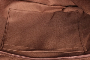 Detail shot of the interior brown fabric lining with an open pocket and zipper closure