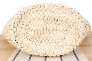 Close-up of the woven base of this handmade straw bag showing oval weave texture
