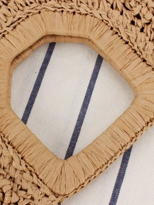 Handwoven moon-shaped bohemian straw handbag with intricate knit texture and top handle
