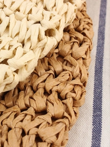 Handwoven round straw shoulder bag in beige and natural tones for seaside beach holidays