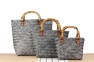 Three-piece set of woven handbags with vintage bamboo handles in varying sizes