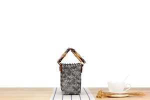 Detail of woven straw tote bag with bamboo handle and premium textured finish