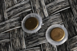Detailed close-up of retro bronze metal decorative buttons on a woven textured background