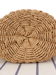 Handwoven straw beach handbag with spiral texture on blue and white striped fabric
