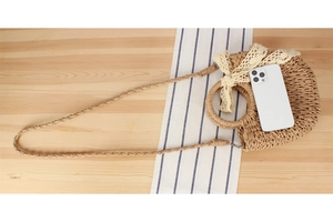 Size reference for straw woven bag with lace bow showing phone and handle detail