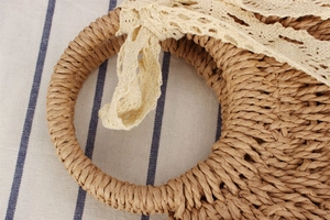 Detailed macro view of natural straw weaving texture and delicate lace ribbon decoration