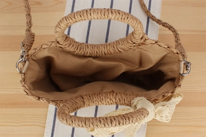 Close-up of woven straw beach bag with fabric lining and decorative lace bow