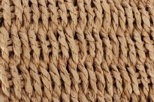 Close-up of natural light brown woven texture on a fashion straw vacation bag