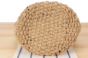 Detailed view of the reinforced round base on a handmade woven straw beach handbag