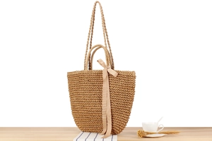 Detailed close-up of woven paper rope shoulder bag with silk bow and twin handles