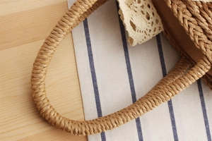 Detailed close-up of handmade paper rope woven bag with elegant beige lace trim