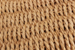 Macro view showing the intricate texture of handwoven paper rope on a beach tote bag