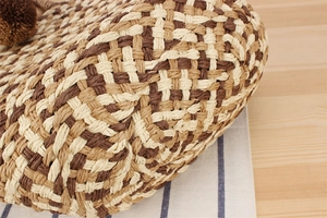 Close-up of checkerboard paper rope weave texture and decorative brown pompom ball
