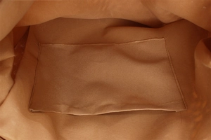 Close-up of the durable canvas lining and functional inner pocket of the woven tote bag