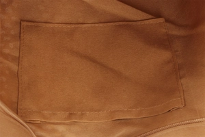 Close-up of brown canvas woven bag interior featuring a functional slip pocket and zipper