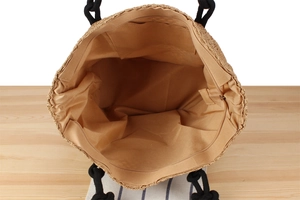Detailed interior of large woven tote with zippered pocket and beige fabric lining