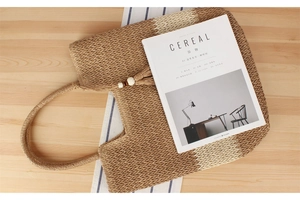 Detalle del bolso tote de paja tejido a mano con asa redonda y cuentas de madera