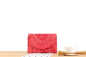 Detailed close-up of red woven corn husk clutch bag with vibrant textured patterns