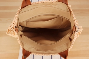 Detail of hand-woven paper rope tote bag showing interior lining and zipper pocket