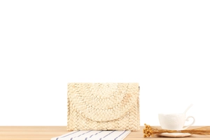 Detailed view of handmade woven corn husk clutch bag with natural straw texture finish