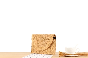 Detail of handmade corn husk woven clutch bag featuring a rounded flap and natural texture