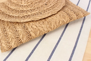 Primer plano del bolso bandolera de cuerda de papel tejida a mano con textura circular caqui