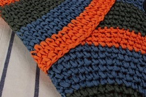 Macro shot of colorful striped hand-woven summer beach tote with orange and blue texture
