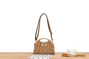 Detail of bohemian paper rope woven bag featuring bead and shell accents on the table