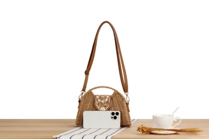 Detail of woven paper rope bag with bead embroidery next to a phone for size reference