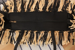 Macro shot of two-tone tassel straw tote with high-quality gold zipper closure