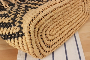 Macro shot of two-tone woven straw beach bag featuring intricate striped texture