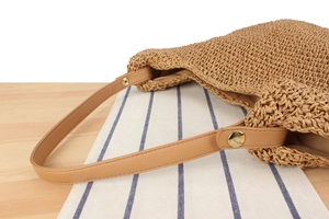 Détail du sac tissé en corde de papier avec bandoulière en similicuir et boucle dorée