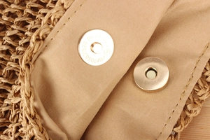 Vue macro d'un sac en paille tressée avec fermoir magnétique et doublure textile