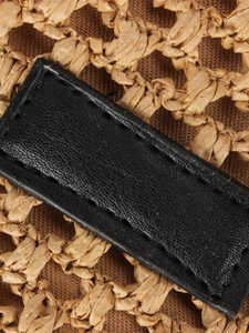 Large woven beach tote featuring black leather strap details and raffia texture
