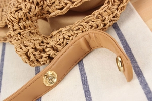 Gros plan d'un sac en corde de papier tissé avec des lanières en cuir et boutons dorés