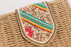 Detail of handmade bead embroidery with floral patterns on woven paper rope straw bag