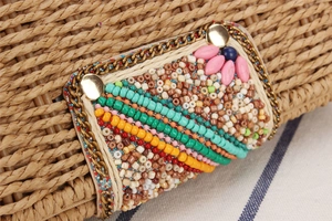 Detail of bohemian paper rope bag with colorful bead embroidery and gold chain trim