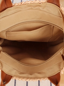 Internal view of handmade woven straw beach bag featuring a zipper pocket and khaki lining