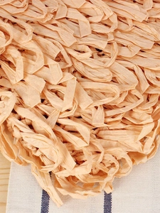 Beige paper rope texture for crochet bags displayed on a rustic cotton linen background