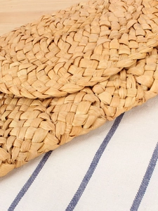 Handmade corn husk woven clutch bag for beach vacation with natural fiber texture