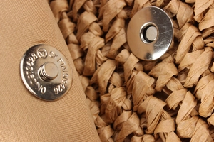 Close-up of the magnetic buckle and straw weave texture of the bohemian beach bag