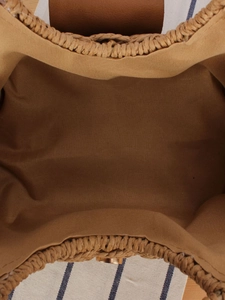 Interior view of minimalist straw woven crossbody bag with brown canvas lining and magnetic snap