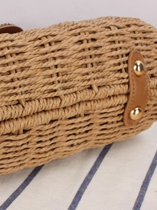 Side view of paper rope woven crossbody bag with leather trim and gold rivet details