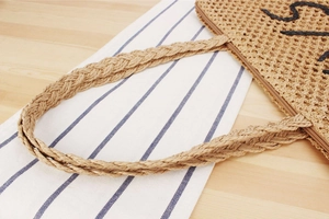 Détail du sac en corde de papier tissé avec anses tressées et fermeture éclair