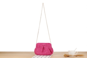 Macro shot of rose red paper rope texture and gold chain strap on beach woven bag