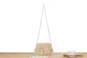Close-up of beige woven paper string cloud bag with a delicate gold chain strap
