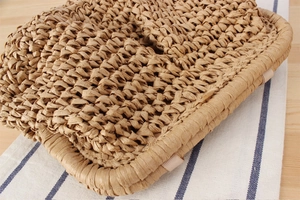 Detailed view of handmade paper rope weaving texture on a rustic straw handbag