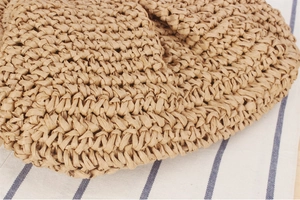 Detailed macro view of brown woven paper straw texture on a handcrafted beach clutch bag